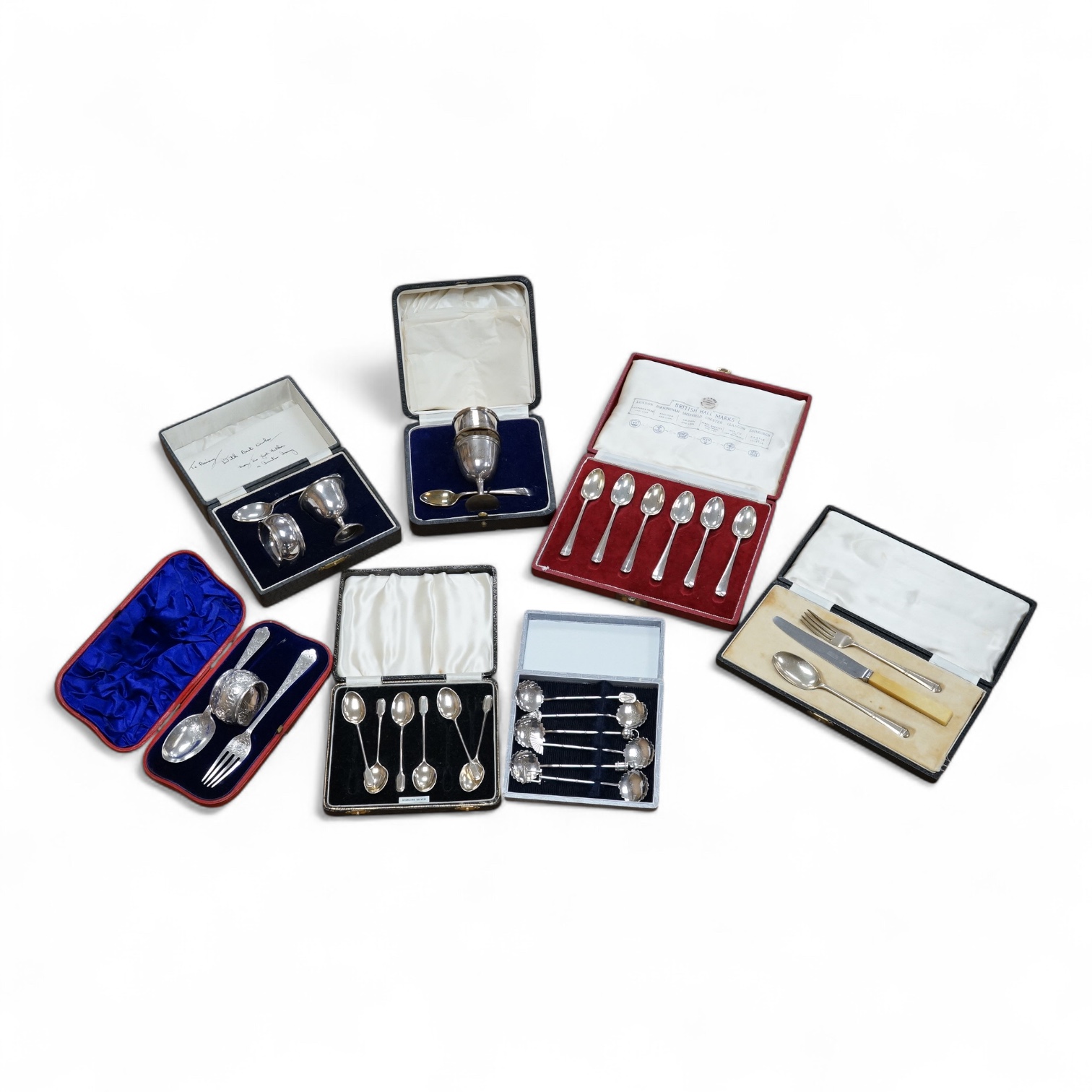 Three assorted silver christening sets including spoon, fork and napkin ring by William Hutton & Sons, London, 1896, one other set with steel knife, two cased sets of silver coffee spoons and a cased set of six Japanese